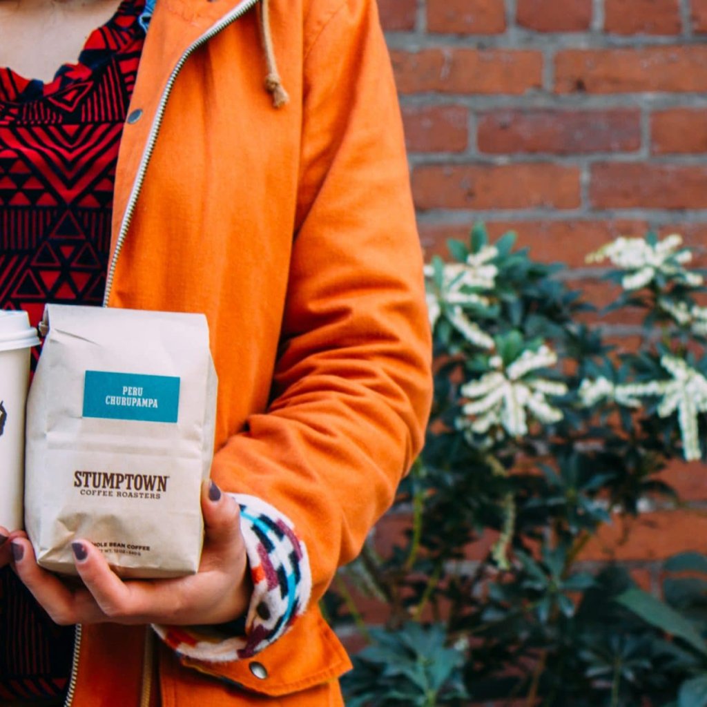 Holding a Stumptown Coffee and bag.