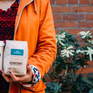 Holding a Stumptown Coffee and bag.