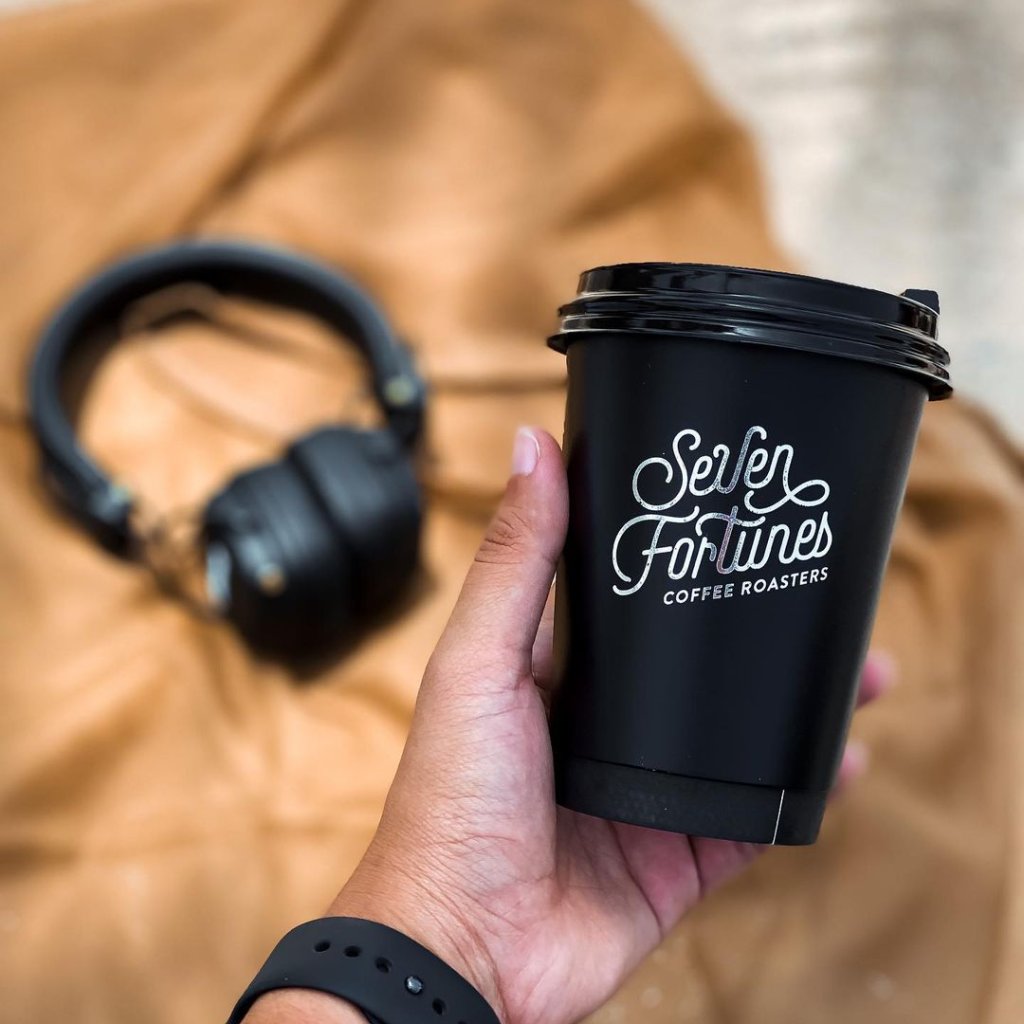Foil version of Seven Fortunes logo on a black to-go cup
