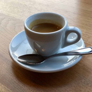 Cup with saucer and spoon, containing espresso